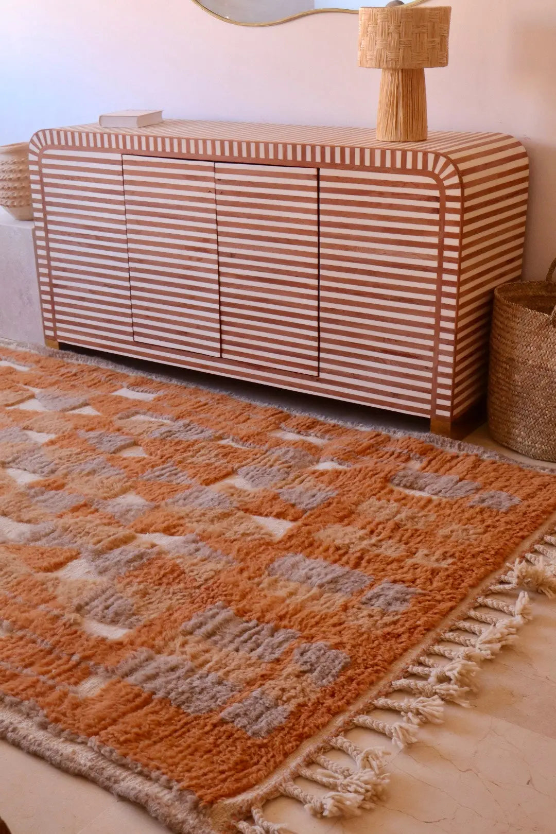 ce somptueux tapis berbère fait main, aux tons chaleureux terracotta, ocre, beige et gris à reliefs. Confectionné en laine pure, il allie tradition et modernité avec ses motifs géométriques élégants. Idéal pour une décoration bohème chic ou contemporain