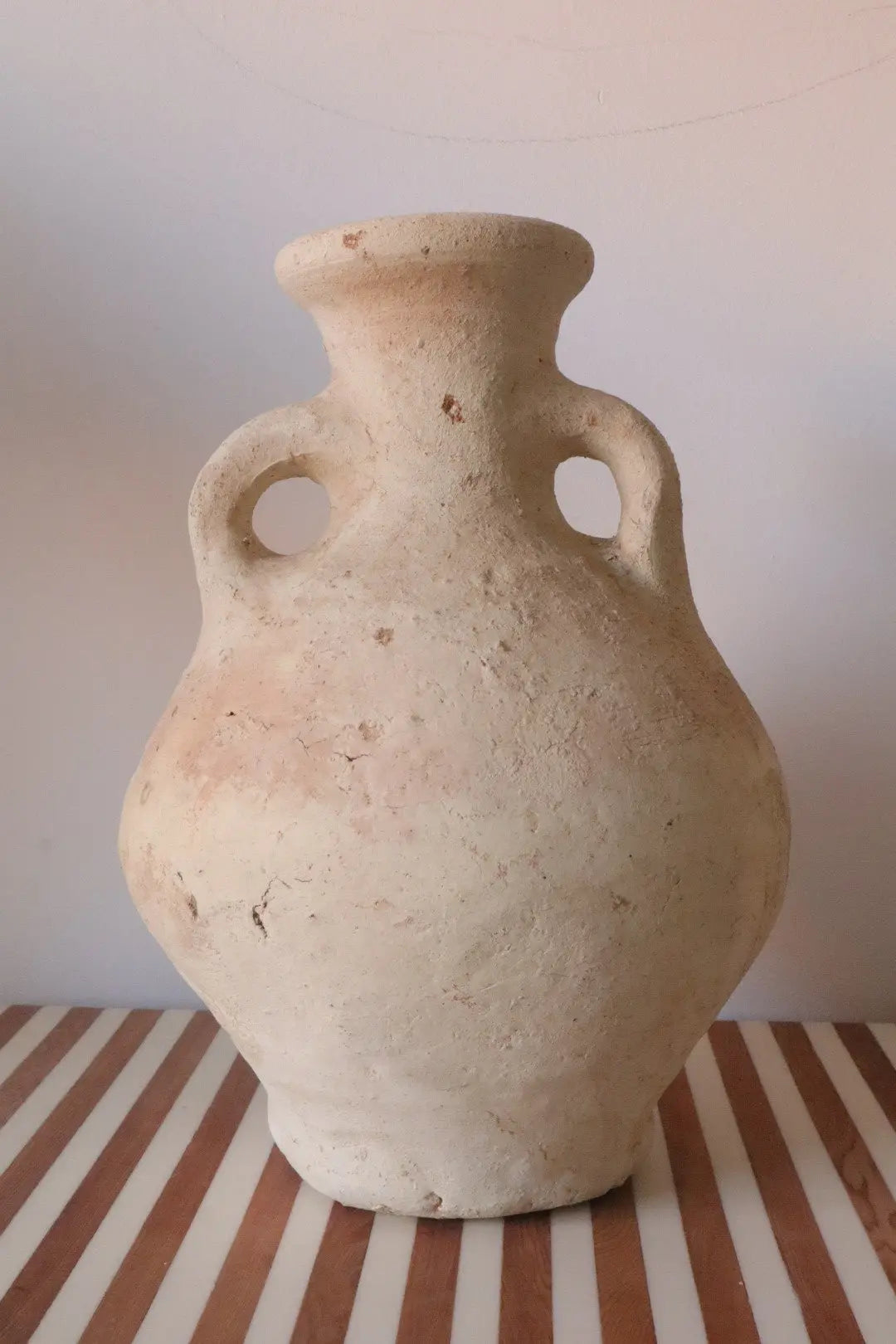 Vase Amphore Sculpture Tamegroute Brute - Blanc Beige Wabi-Sabi

Ce vase sculpture en terre cuite de Tamegroute est une pièce artisanale rare et unique aux lignes organiques et brutes. Fabriqué à la main selon les techniques ancestrales du sud du Maroc (Région de Zagora), ce vase se distingue par sa forme audacieuse et son esthétique naturelle, parfaite pour un décor bohème ou wabi-sabi.

Très prisé des amateurs de décoration, le Tamegroute est un art authentique et rare, propre à cette région désertique, q