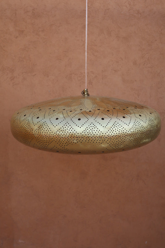 Suspension en laiton fait main, ornée de motifs géométriques perforés, diffusant une lumière féerique avec un effet d’ombres projetées sur le mur. Design artisanal inspiré des Mille et Une Nuits, idéale pour une décoration élégante et intemporelle. Suspension en laiton orientale Neda-artisanat 